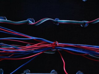 Bright colored LED wires contrast sharply against the dark background.  Tangled colorful wires...