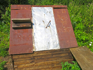rural street well with an iron roof