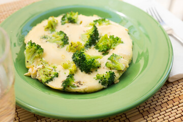 Wholesome breakfast. omelet with broccoli on green plate