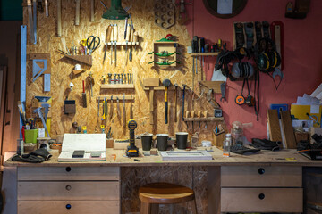 Orderly workspace in woodworking studio, tools hanging neatly in designated places. Organized work tools in carpentry, efficient setup, workshop tidiness, systematic layout, precision craft