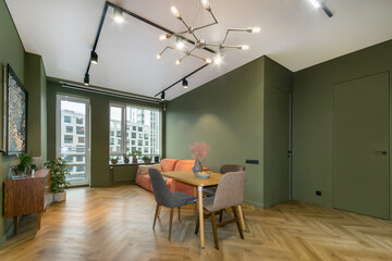 Studio apartment with modern interior design. Parquet floors, gray-green walls and stylish furniture.
