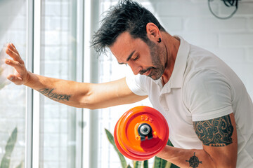 young man lifting dumbbell doing biceps