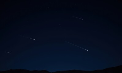 Streaking meteors in a dark night sky