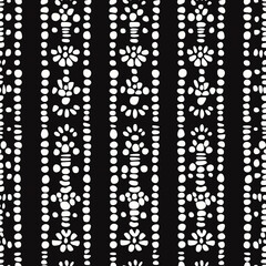 Black background with white floral and dot patterns arranged in vertical stripes, creating a bold and modern design.
