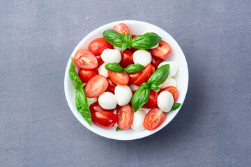 Basil leaves , cherry tomatoes and mozzarella cheese . In bowl food photography