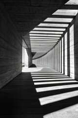 Fototapeta premium Concrete Corridor: A stark yet beautiful image of a concrete corridor with a curved ceiling and long, thin windows, casting long, dramatic shadows on the floor.