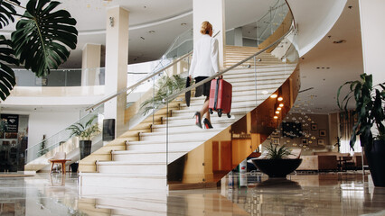 A modern blonde businesswoman arrives at a business hotel during a business trip. Business woman director who came on a business trip.