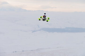 flying homemade drone with bright details on the body in abstract winter environment, close-up. hobby for adults