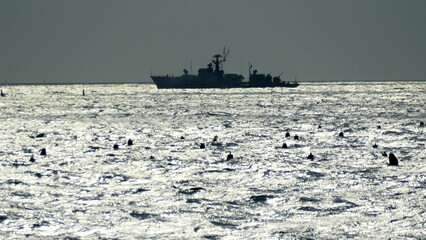 silhouette of a warship at sea