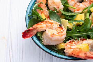 Salad with tiger shrimps , avocado and mango . Top view