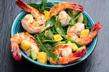 Salad with tiger shrimps , avocado and mango . Top view