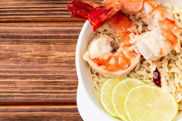 Tom yum soup with shrimps instant noodles and lime photography . Asian food . Top view