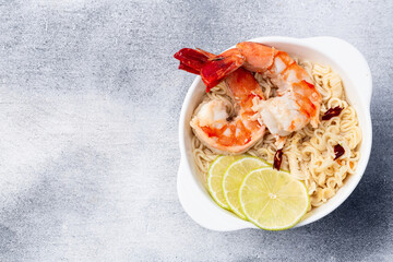 Tom yum soup with shrimps instant noodles and lime photography . Asian food . Top view