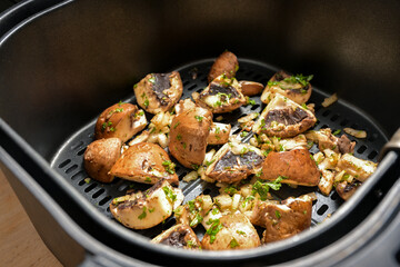 Mushrooms with herbs, spices and a little oil are baked in a hot air fryer, healthy method of cooking vegetables, selected focus
