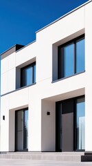 A modern smart home exterior featuring sleek, minimalist architecture with large windows and a clear blue sky backdrop.