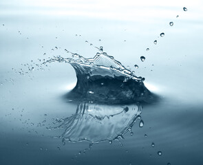 Splashes from a drop of blue water