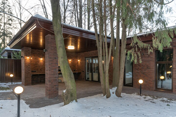 Magnificent design of a gazebo with a barbecue oven on a private territory surrounded by a forest...