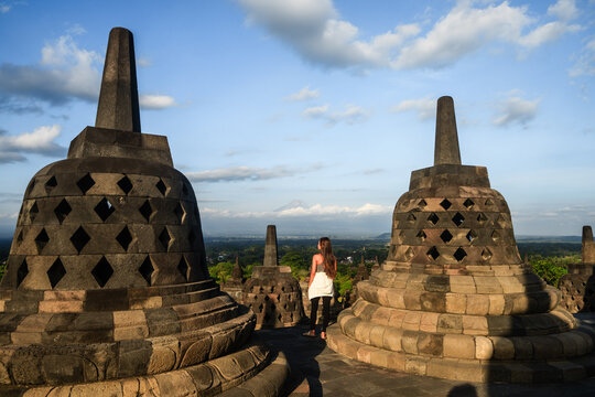 Asian woman visiting Borobudur temple at sunset, Central Java, Indonesia