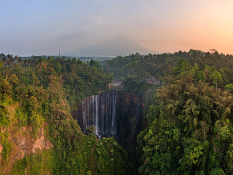 Aerial view of Tumpak Sewu waterfall and volcano at sunset, Indonesia