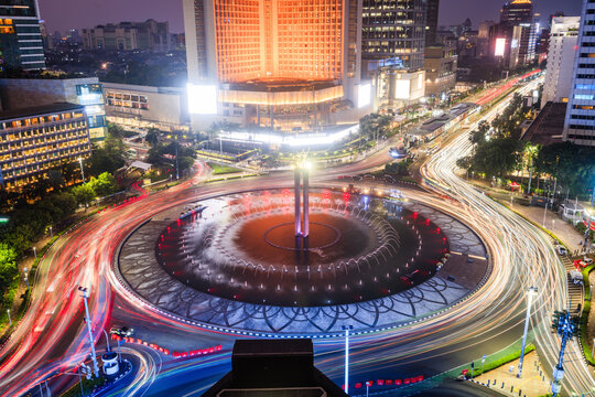 HI Roundabout at night with light trails in Jakarta city at dusk, Java, Indonesia