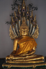 Fototapeta premium Statue of Buddha guarded by a serpent at Wat Arun, Bangkok 