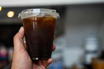 Iced Americano black coffee on hand in hot day