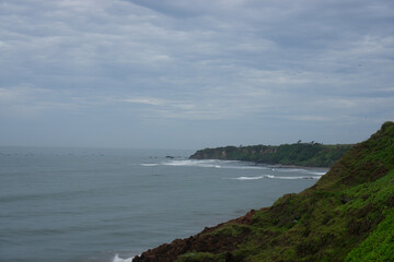 view of cliffs and sea at the top of guha garut,west java. with cliffs and sea and blue sky  filled with clouds