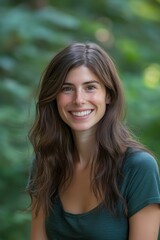 Fototapeta premium Smiling woman, long brown hair, teal shirt, outdoors.