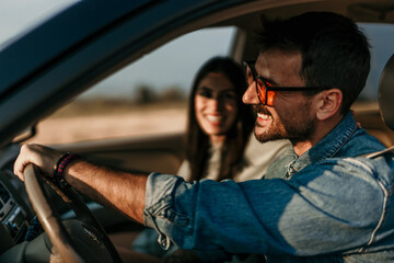 Happy couple driving together, enjoying a scenic sunset on a road trip