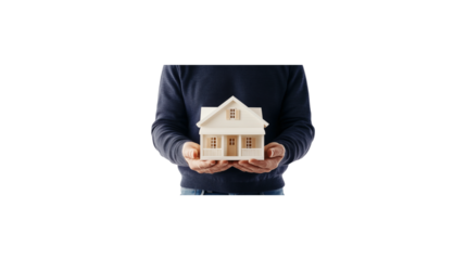 A person is holding a small house in their hands. The house is made of wood and has a white roof. The person is wearing a sweater and he is holding the house with care. transparent background