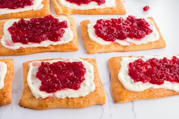 Pastries with cream cheese and berry jam close-up.