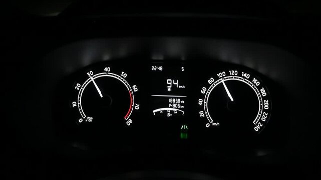 Modern dashboard in the car at night. Illuminated tach and speed gauges on car dashboard. Driver's view on dashboard in a vehicle during driving.  