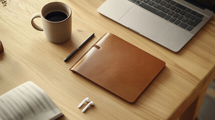Cozy workspace with a leather notebook, coffee, and laptop on a wooden desk