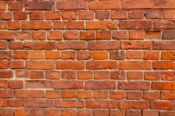 Brick wall with textured red surface revealing the craftsmanship and durability of traditional masonry used in construction.