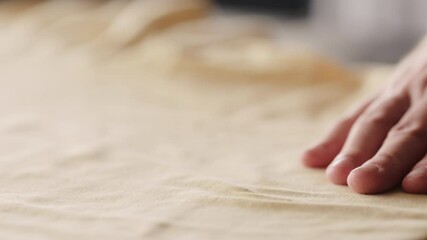 Slow motion man touching yellow cotton clothes closeup