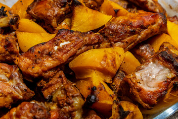 Deliciously grilled meat and roasted squash served on a platter at a festive gathering in a warm, inviting setting during a summer evening.