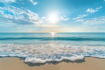 Obraz premium Soft waves lap a sunny beach under a bright blue sky. Perfect for travel, vacation, or summer themes.