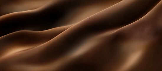 Fototapeta premium Brown velvet fabric background with shadows and soft lighting, creating an elegant texture.