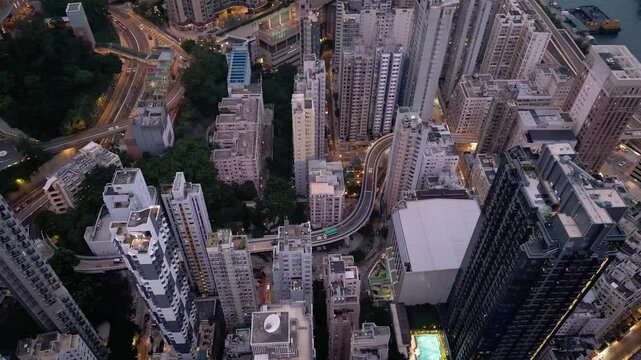 Hong Kong: Aerial drone footage of the elevated road going through the very densely populated district of Sai Wan and Sai Ying Pun in Hong Kong island. Shot with a tilt down motion 