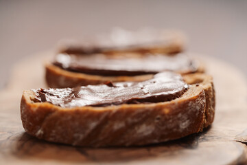 Ciabatta slices with chocolate spread on olive wood board