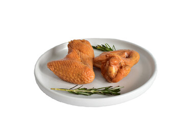 Ready-to-eat smoked chicken wings lie on a white clay plate.