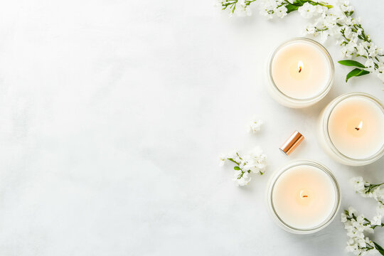 Scented white candles with blossoms on white background - Powered by Adobe