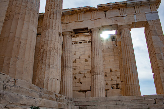 wall of Greek columns, against the background of bright rays of the sun, acropolis