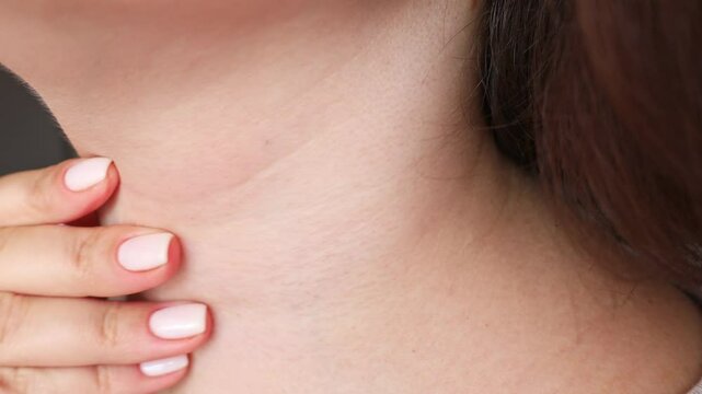 Woman with sore throat touching neck with a hand, suffer from painful swallowing, tonsillitis, irritation or thyroid gland salivary disease
