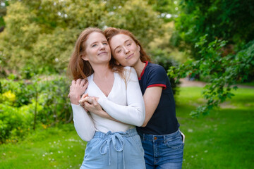 Fototapeta premium Two friends enjoying a joyful moment together in a lush green park on a sunny day