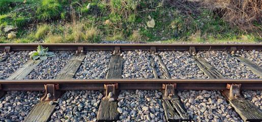 Close up of section of old railway track with sleepers, ballast, iron, railroad ties,  fasteners,...
