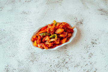 Sweet and Sour Chicken with Bell Peppers on a White Plate