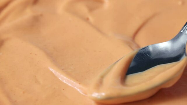Homemade American burger sauce or thousand island dressing spreading with a spoon close up