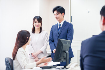 Fototapeta premium 職場で上司に結婚の報告をするビジネスパーソンのカップル