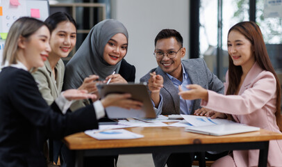 Happy asian business woman executive ceo leader discussing project management planning strategy working with diverse colleagues company team at office corporate board group meeting.
